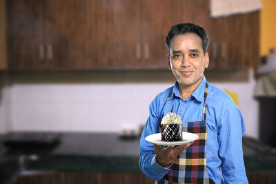 Portrait of a smiling man holding ice cream