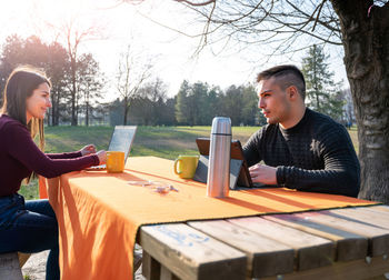 Portrait of man using mobile phone while sitting on table