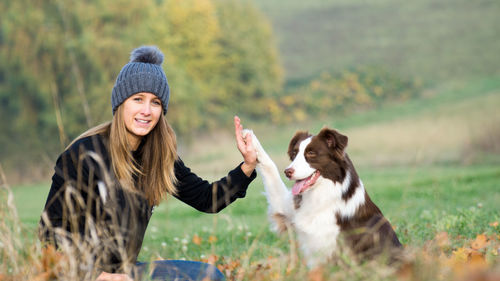 Portrait of woman with dog on grass