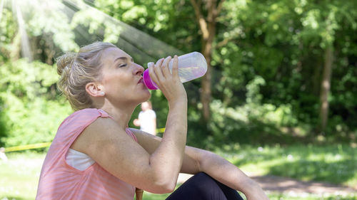 Midsection of woman drinking water from bottle