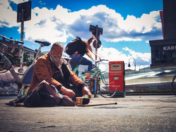 People sitting on street against sky