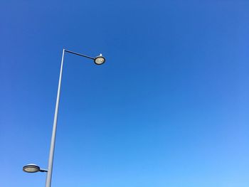 Low angle view of street light against blue sky