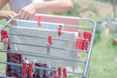 Cropped image of woman drying clothes from laundry rack