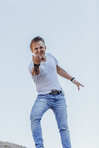 Low angle view of man standing against clear sky