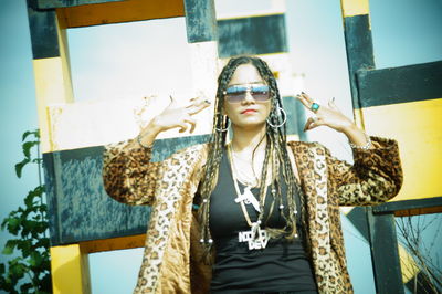 Portrait of young woman wearing sunglasses standing outdoors
