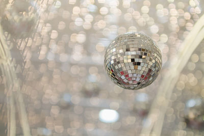 Low angle view of disco ball against christmas lights