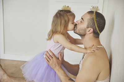 Father and daughter play dressed up as princesses