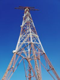 Low angle view of ferris wheel against clear blue sky