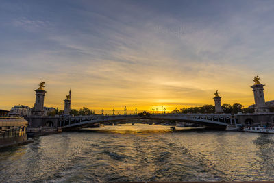 Bridge over river at sunset