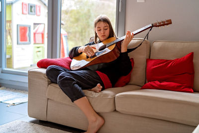 Boy sitting on sofa at home