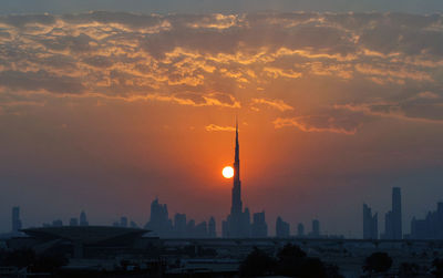 Dubai skyline against cloudy sky during sunset