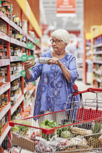 Senior woman using barcode reader in shop