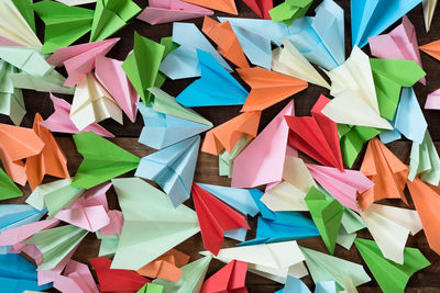 High angle view of multi colored paper airplane on table