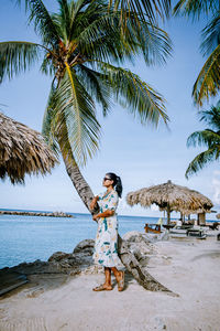 Woman standing at beach against sky