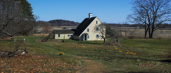 House on field against clear sky