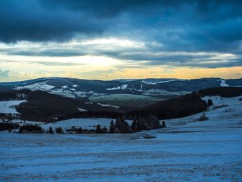 Scenic view of snowcapped mountains against dramatic sky