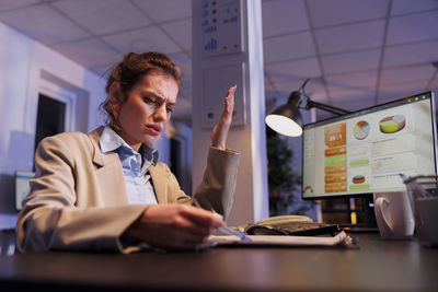 Portrait of young woman using laptop at office