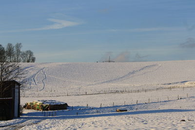 Scenic view of snow covered field against sky