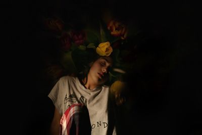 Close-up of woman napping against floral patterned wall