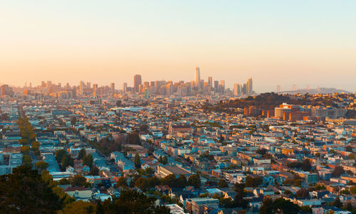 Aerial view of buildings in city against clear sky