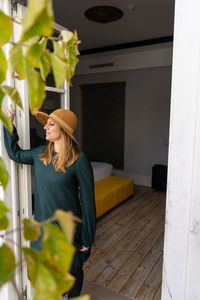 Woman looking away while standing at home