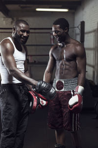 Happy boxer standing in gym