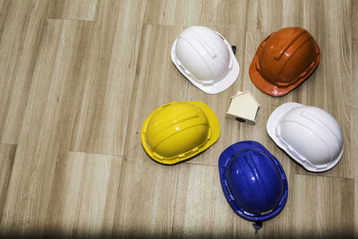 Multi colored helmets and model house on table