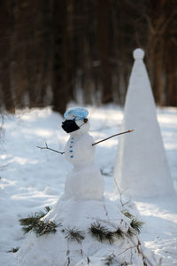 Snowman in the forest wearing protective face mask. covid19 and quarantin concept. 