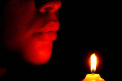 Close-up of lit candle in dark room