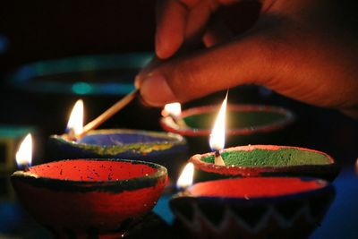 Close-up of human hand with candle