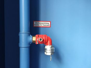 Close-up of pipe against blue wall