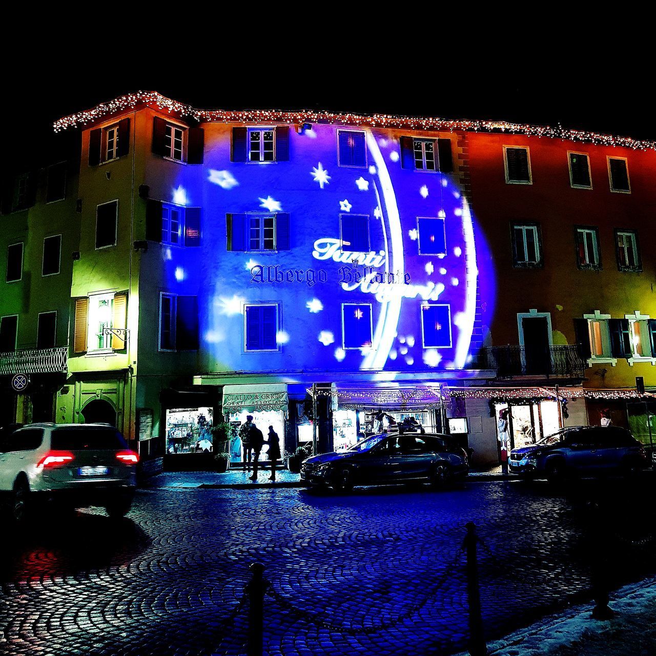 PEOPLE ON ILLUMINATED BUILDING AT NIGHT