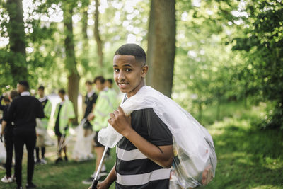 Portrait of boy with garbage bag over shoulder