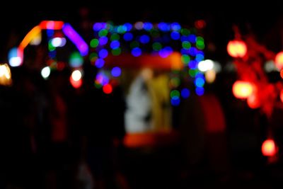 Defocused image of illuminated lights in city at night