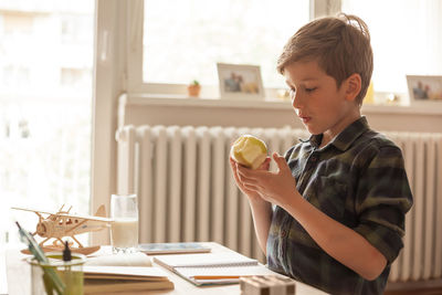 Boy holding ice cream on table