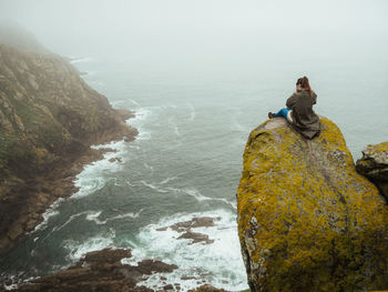 Rock looking at sea against sky