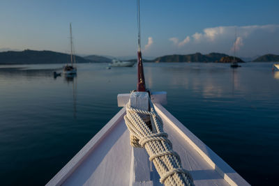 Close-up of boat moored in lake against sky