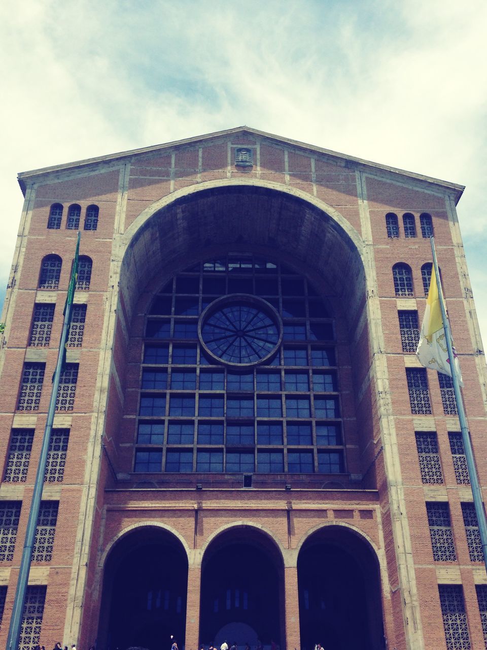 architecture, built structure, arch, building exterior, low angle view, sky, window, text, facade, day, cloud - sky, building, outdoors, cloud, no people, history, brick wall, western script, entrance, communication