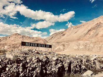 Panoramic shot of text on rock against sky