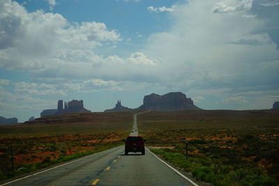 Country road against cloudy sky