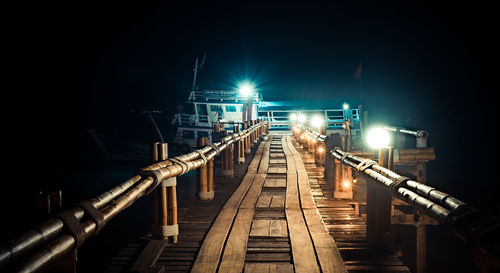 Illuminated bridge against sky at night