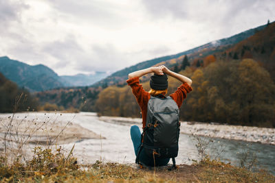 Rear view of man on mountain against sky