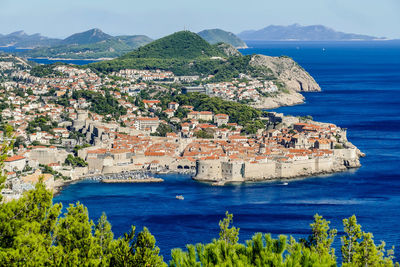 Scenic view of sea by town against sky