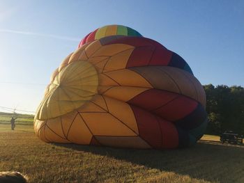 Multi colored hot air balloons on field against sky