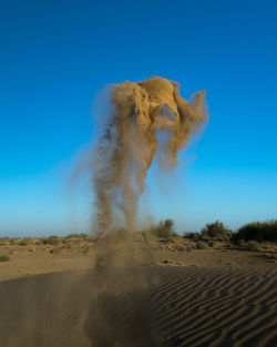 Scenic view of arid landscape against clear blue sky