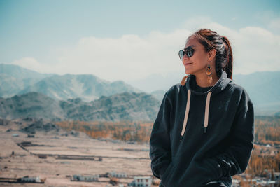 Smiling woman looking away against mountains