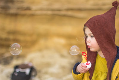 Portrait of woman with bubbles in park