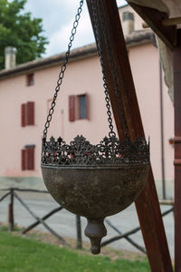 Close-up of metal chain hanging outside house in yard