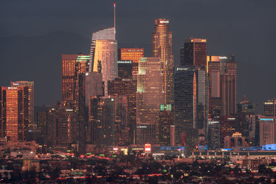 Illuminated buildings against sky at night