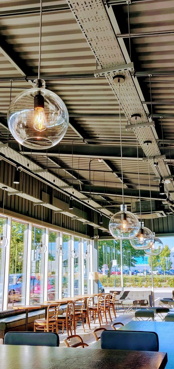 indoors, no people, table, hanging, lighting equipment, ceiling, seat, chair, empty, business, architecture, illuminated, absence, day, in a row, large group of objects, glass - material, built structure, metal, low angle view, glass, light
